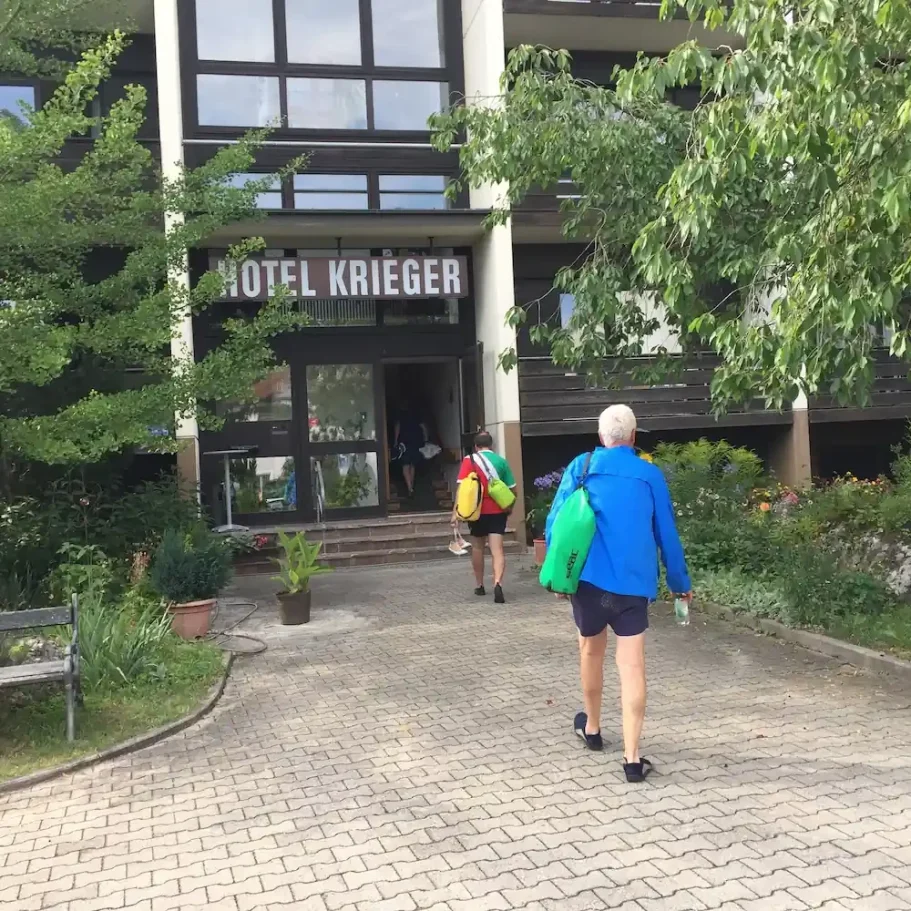 Willkommen im Hotel Krieger: Idealer Stopp für Radler in Mariaort. Radfahrer vor dem Eingang des Hotel Krieger in Mariaort – Ihr fahrradfreundliches Hotel am Radweg bei Regensburg.